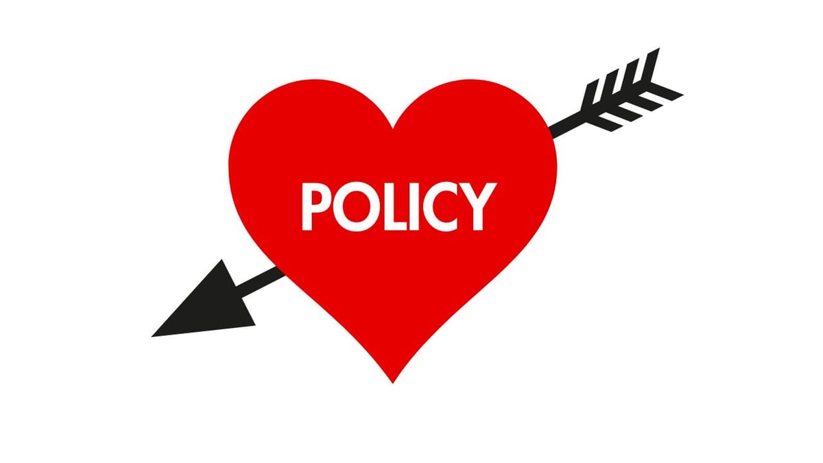 Cupid's Heart reading POLICY with arrow going through it. 