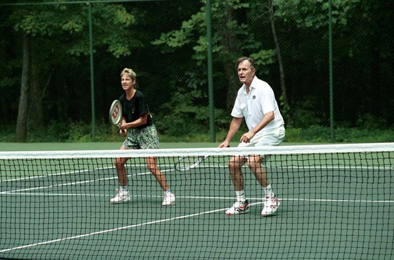 President George H. W. Bush playing tennis with Chris Evert. 