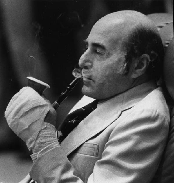 Senator George Firestone smokes a pipe. 