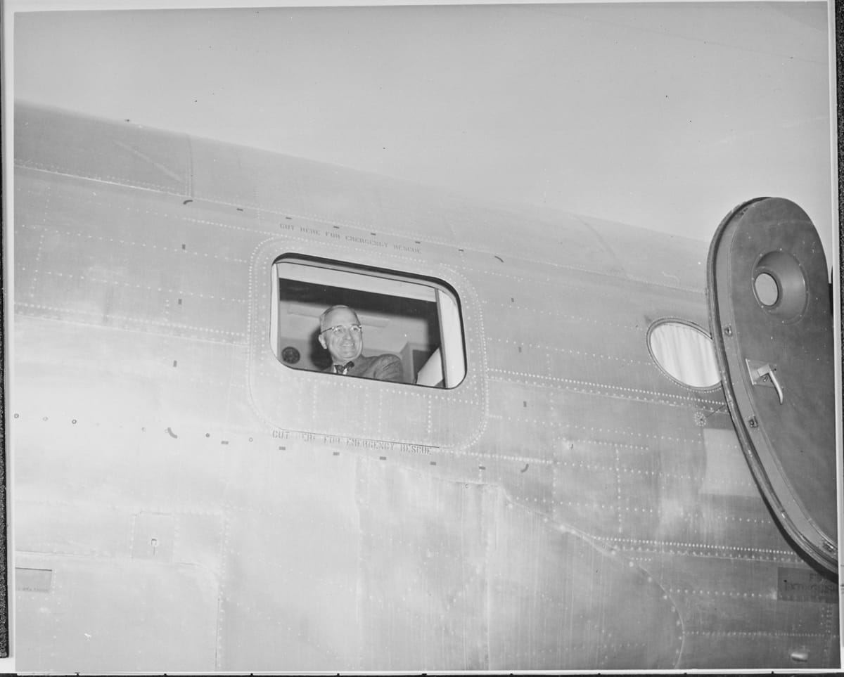 President Truman looks out an airplane window 