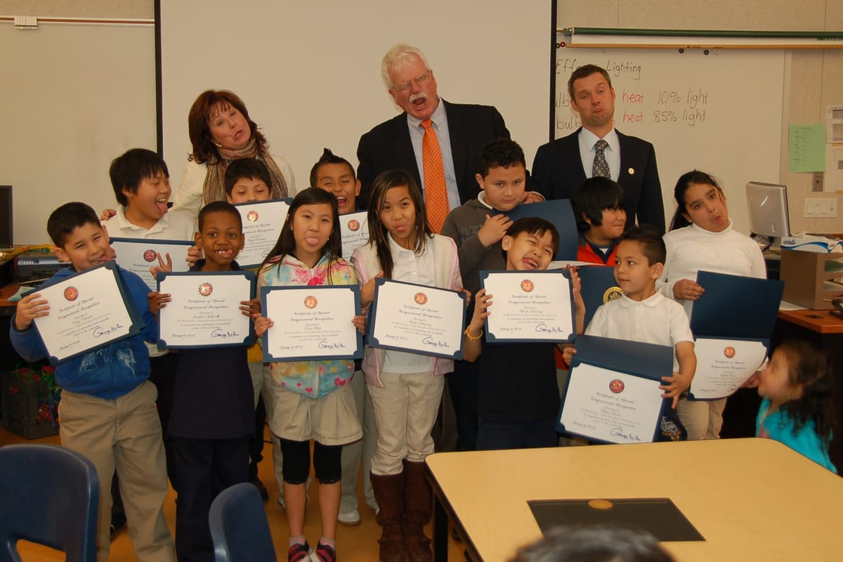 Congressman George Miller makes a funny face while meeting with kids in a classroom. 